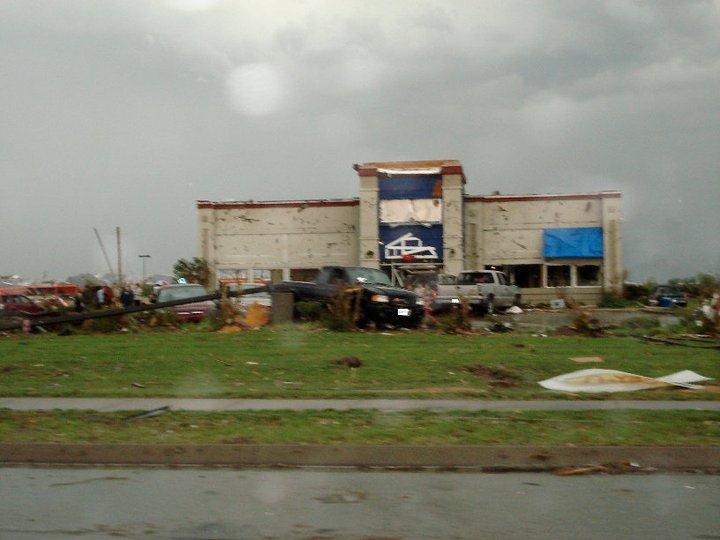 Building with some damage, light poles pushed over.